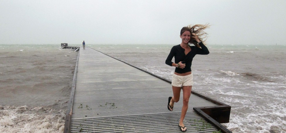 Unidentified woman leaves pier in high wind and rough surf as Tropical Storm Isaac moves over the island