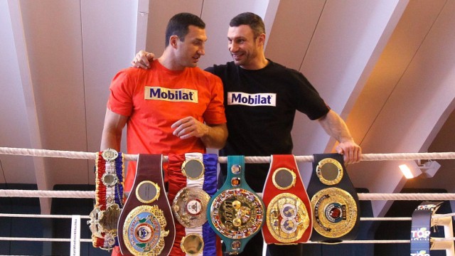 Ukranian heavyweight boxers Vladimir and Vitali Klitschko pose with their world championship titles belts at training camp in Going