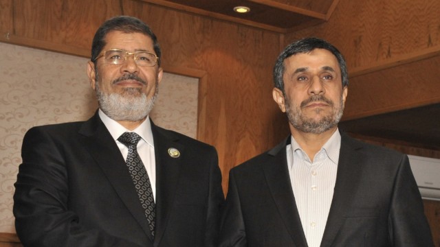 Egypt's President Mohamed Mursi shakes hands with Iran's President Mahmoud Ahmadinejad during the 16th summit of the Non-Aligned Movement in Tehran