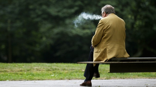 A man smokes a cigarette during a pause in the senior delegates meeting of the conservative Christian Democratic Union (CDU) in the western city of Recklinghausen