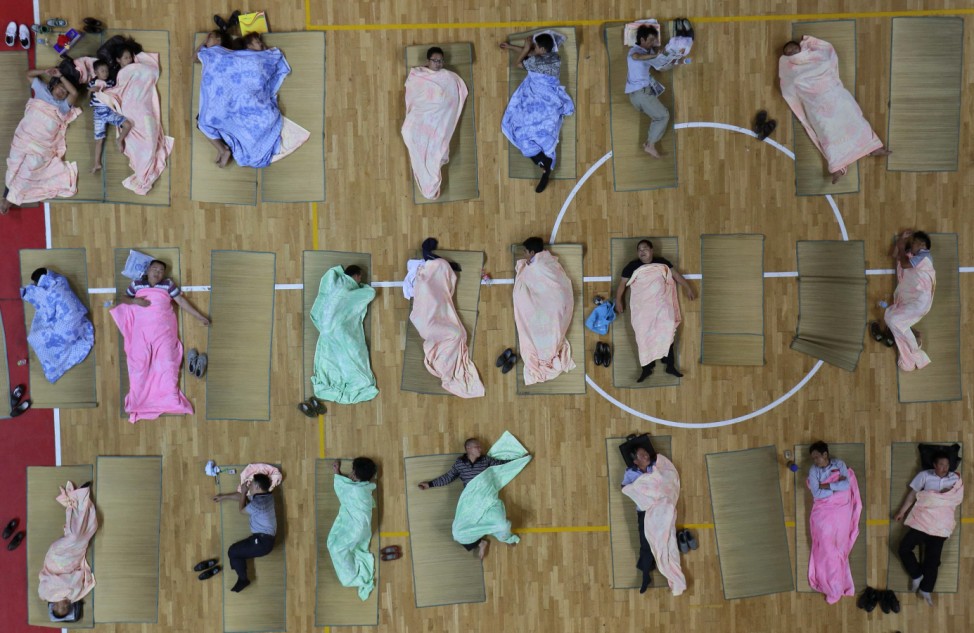 Parents of freshmen students sleep on mats laid out on the floor of a gymnasium at Huazhong Normal University in Wuhan