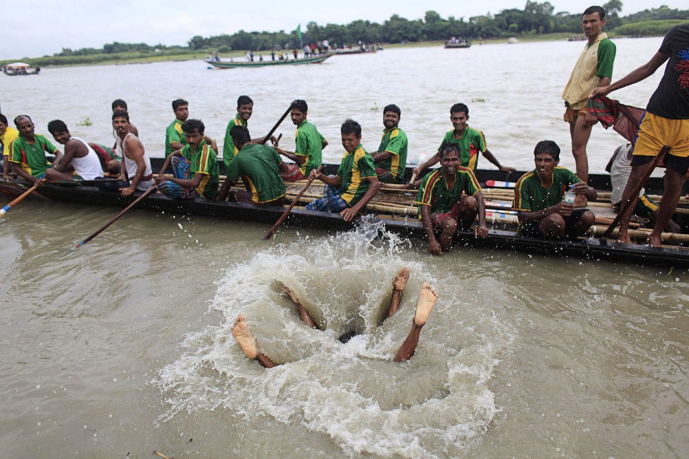 Boatman jumps into the Kaliganga river as they prepare for a traditional boat race at Manikganj
