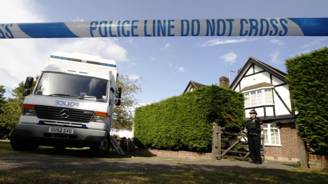 A police officer stands by a cordon close to the house of Saad al-Hilli and his family in Claygate near London