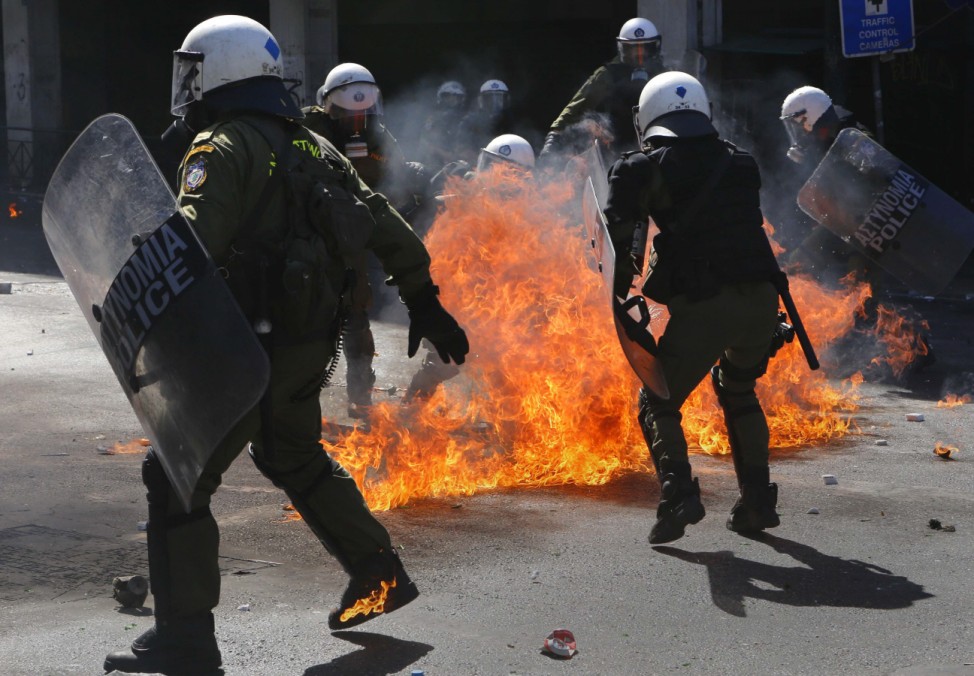 Riot police officers try to avoid petrol bombs thrown by protesters in Athens' Syntagma square during a 24-hour labour strike