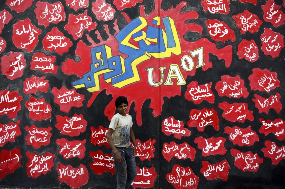 A boy walks past graffiti along Mohamed Mahmoud street near Tahrir Square in Cairo