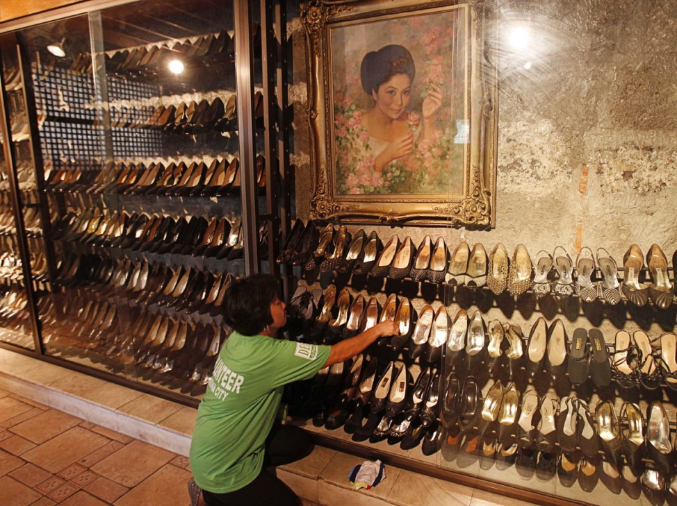 Volunteer cleans shoes of former Philippine First Lady Imelda Marcos on display at Marikina Footwear Museum