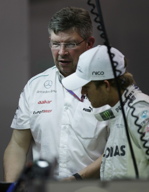 Mercedes Formula One Team Principal Brawn speaks to driver Rosberg of Germany in the team's garage at the Marina Bay Street Circuit ahead of the Singapore F1 Grand Prix