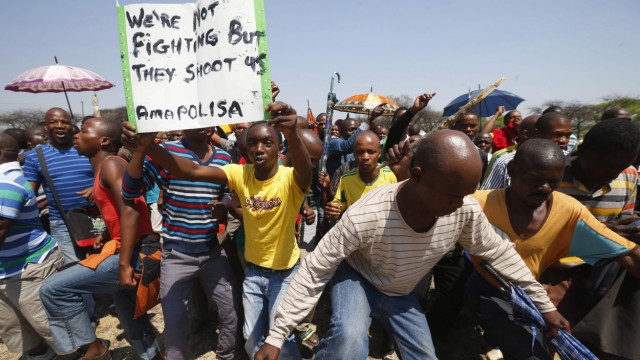 Striking platinum miners march near the Anglo-American Platinum (AMPLATS) mine near Rustenburg in South Africa's North West Province