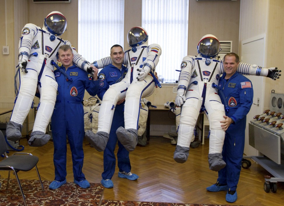 The International Space Station (ISS) crew members, U.S. astronaut Kevin Ford and Russian cosmonauts Evgeny Tarelkin and Oleg Novitskiy, pose with their inflated space suits as they conduct training at Baikonur cosmodrome