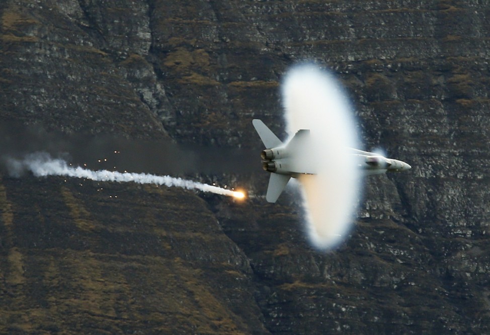 A Swiss Air Force F18 fighter jet releases flares during a flight demonstration of the Swiss Air Force over the Axalp