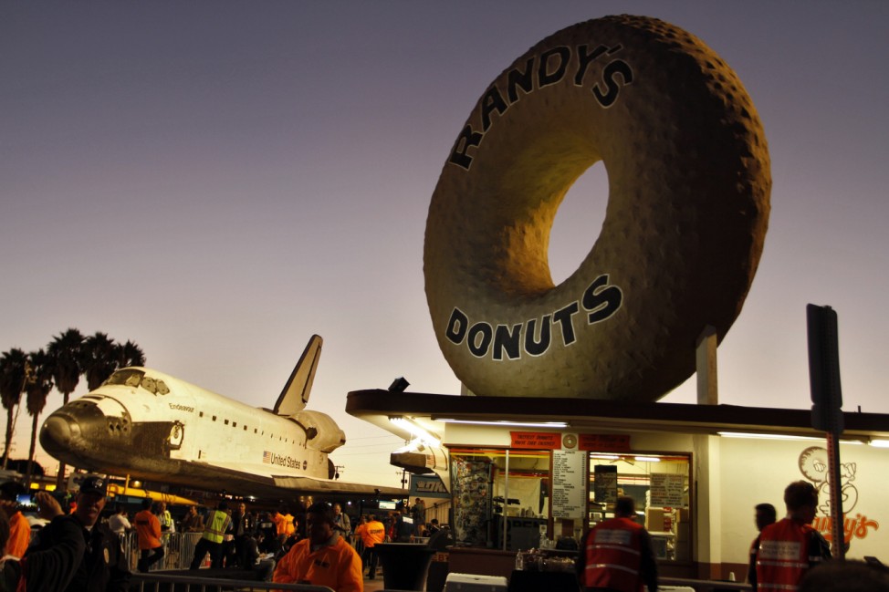 Space Shuttle Endeavour stops in front of Randy's Donuts as it's transported on Manchester Avenue in Los Angeles, California
