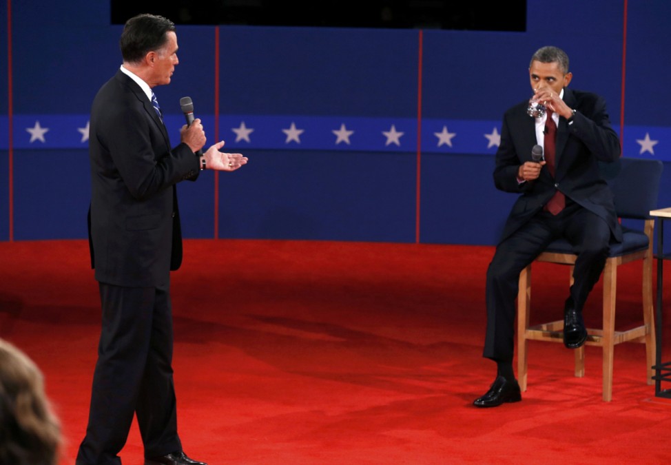 U.S. President Obama listens as Republican presidential nominee Romney answers a question during the second U.S. presidential debate in Hempstead