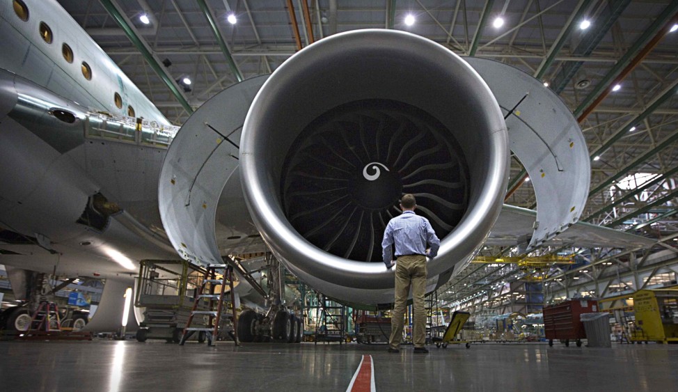 A worker stands in front of an engine on the Boeing 777 at their assembly operations in Everett