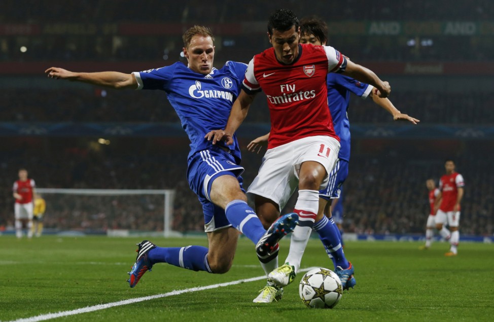 Arsenal's Andre Santos is challenged by Schalke 04's Benedikt Howedes during their Champions League Group B soccer match in London