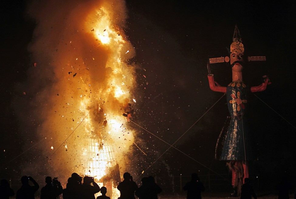 Photographers take pictures of an effigy of Meghnad after it is set on fire during the festival of Dussehra in Srinagar