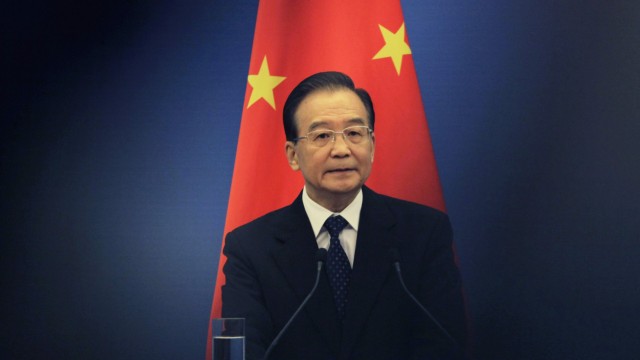 File photo of China's Premier Wen Jiabao standing in front of a Chinese national flag at the Great Hall of the People in Beijing