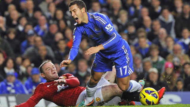 Manchester United's Rooney makes a late tackle on Chelsea's Hazard to earn himself a yellow card during their English Premier League soccer match in London
