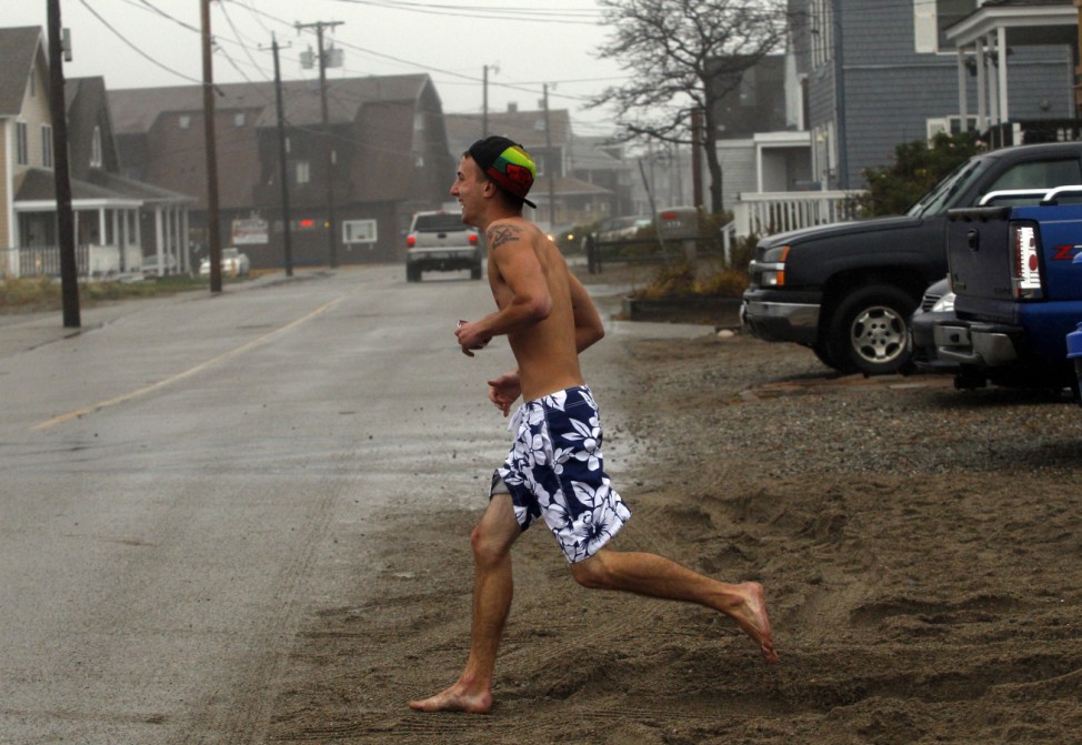A man runs from the beach as Hurricane Sandy approaches in Scituate