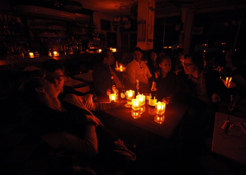 Customers and staff ride out Hurricane Sandy together by candle light at the Greenwich Village restaurant French Roast in New York