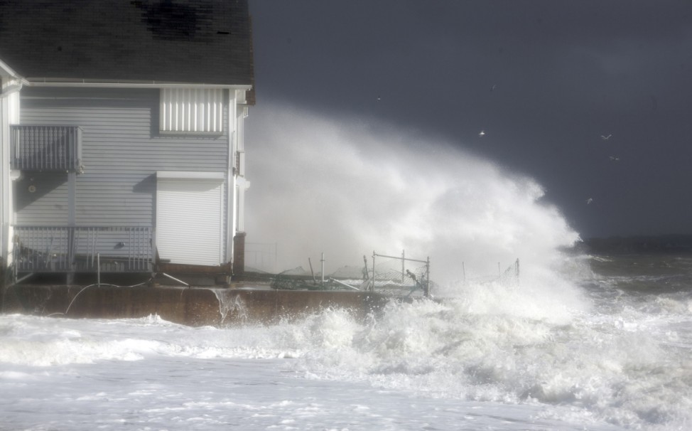 Waves crash against the shoreline during high tide in Milford, Connecticut