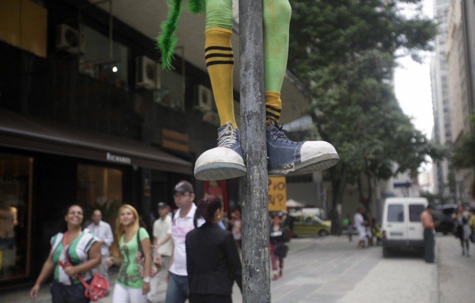 A reveller climbs up a lamp post during a clown parade in Rio de Janeiro