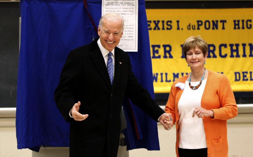 U.S. Vice President Biden holds hands with a poll worker as he emerges from the voting booth after casting his ballot during the U.S. presidential election in Greenville