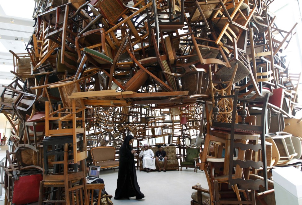 A visitor walks within an installation titled 'Chairs' by Japanese artist Tadashi Kawamata during Abu Dhabi Art at Saadiyat island