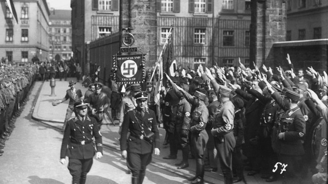 Polizei im Nationalsozialismus: Triumphierend holten die Nazis 1933 die so genannte "Blutfahne" aus der Ettstraße ab, die seit dem Putschversuch von 1923 konfisziert war.