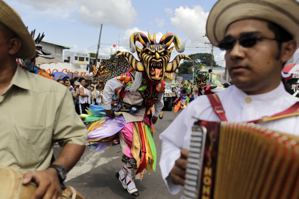 A man wearing a mask takes part in a parade commemorating the 'Grito de La Villa de Los Santos' in La Chorrera