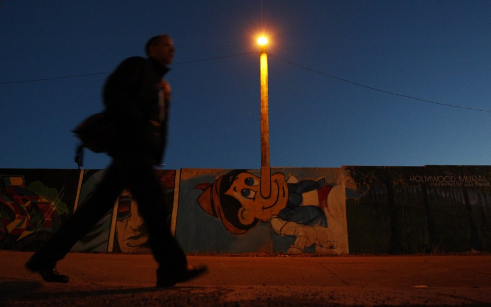 A pedestrian walks past mural of Pinocchio in Ottawa