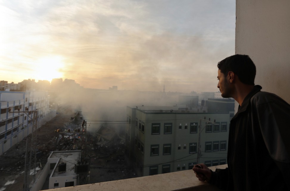 A Palestinian man looks at the building of Hamas ministry of interior damaged in an Israeli air strike in Gaza City