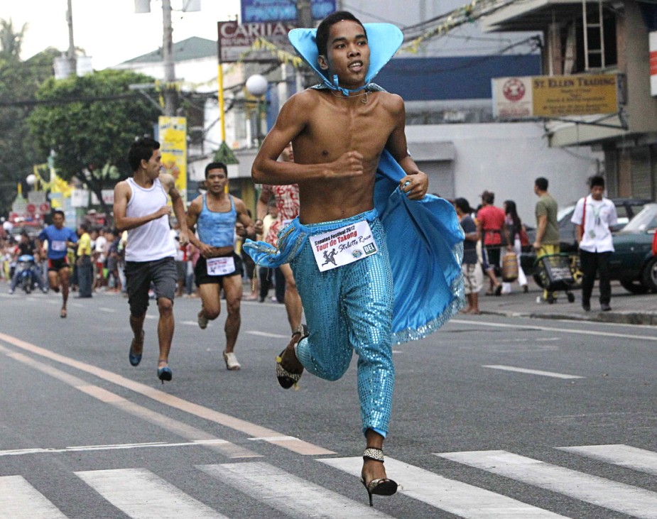 A male Tour De Takong (Stiletto Race) participant runs along the 500 m stretch of Shoe Avenue in Marikina City, east of Manila