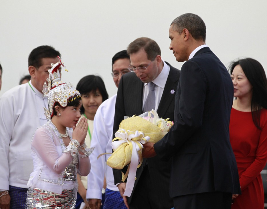A girl gestures after presenting U.S. President Barack Obama with a bouquet of flowers upon his arrival at Yangon International Airport