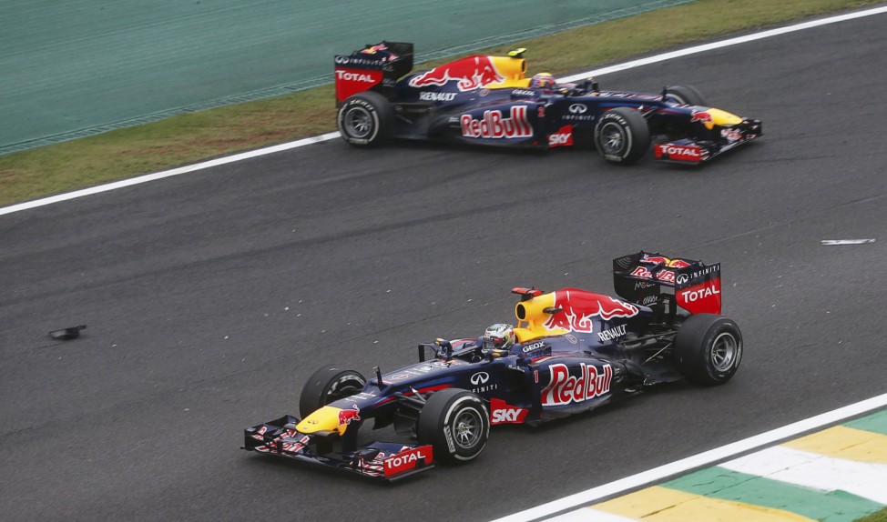 Red Bull Formula One driver Sebastian Vettel of Germany  drives past team mate Mark Webber of Australia after Webber spun out during the Brazilian F1 Grand Prix