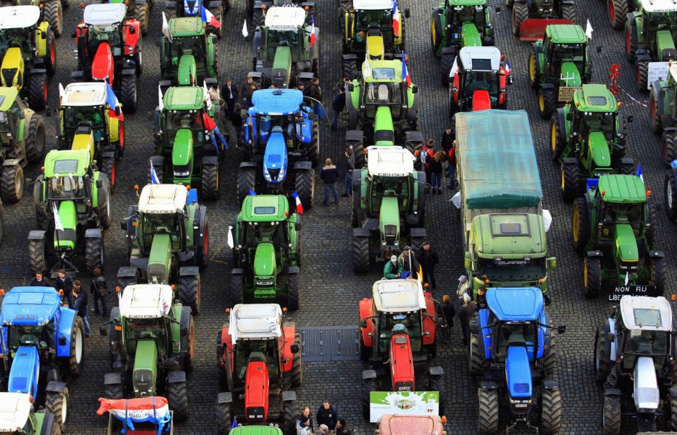 File picture shows farmers standing amidst hundreds of tractors during a demonstration by European milk producers in central Brussels