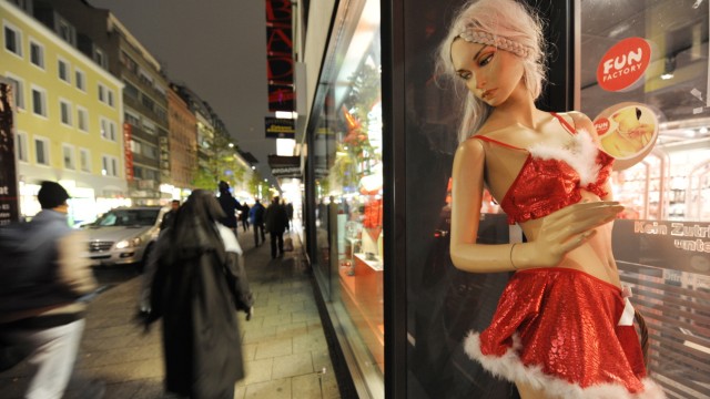 Münchner Bahnhofsviertel: Vor einem Sexshop steht eine Puppe in weihnachtlichtem Kostüm.