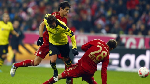 Badstuber of Bayern Munich twists his knee as he challenges Goetze of Borusia Dortmund during their German Bundesliga soccer match in Munich