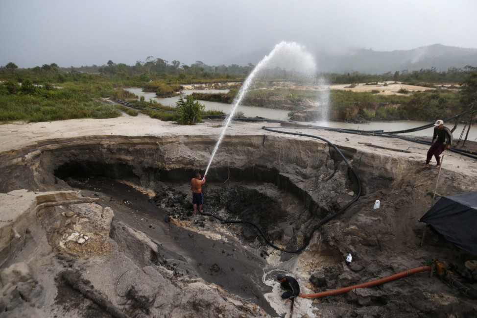 Miners dig with pressure hoses near the town of Ikabaru in the south of Venezuela