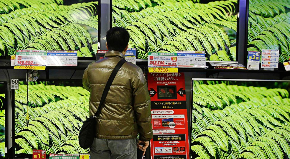 A man looks at Sharp Corp's Aquos television sets displayed at an electronics store in Tokyo