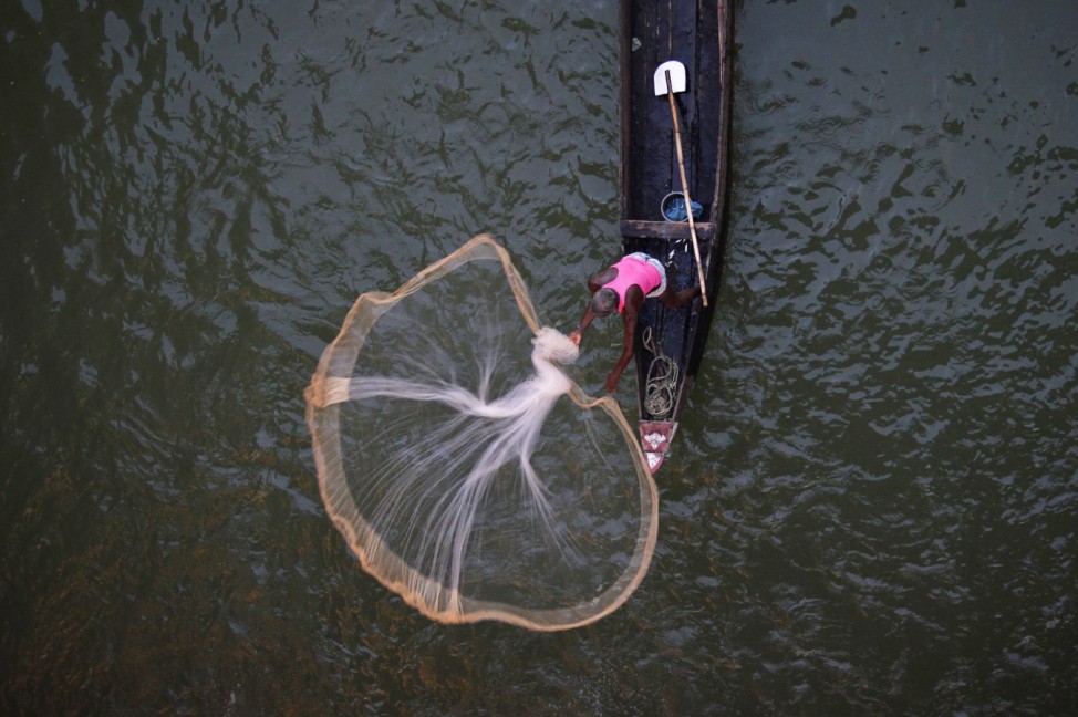 A fisherman casts his net into the Kathajodi River in Cuttack district, about 25 km (15 miles) from Bhubaneswar