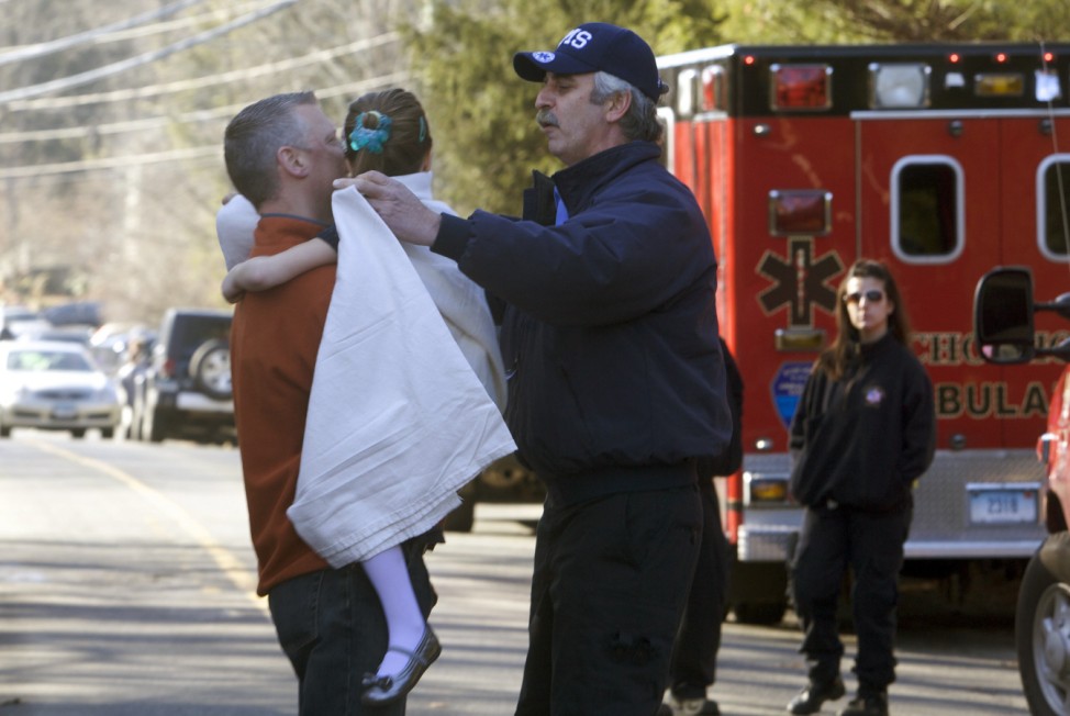 A young girl is given a blanket after being evacuated from Sandy Hook Elementary School following a shooting in Newtown