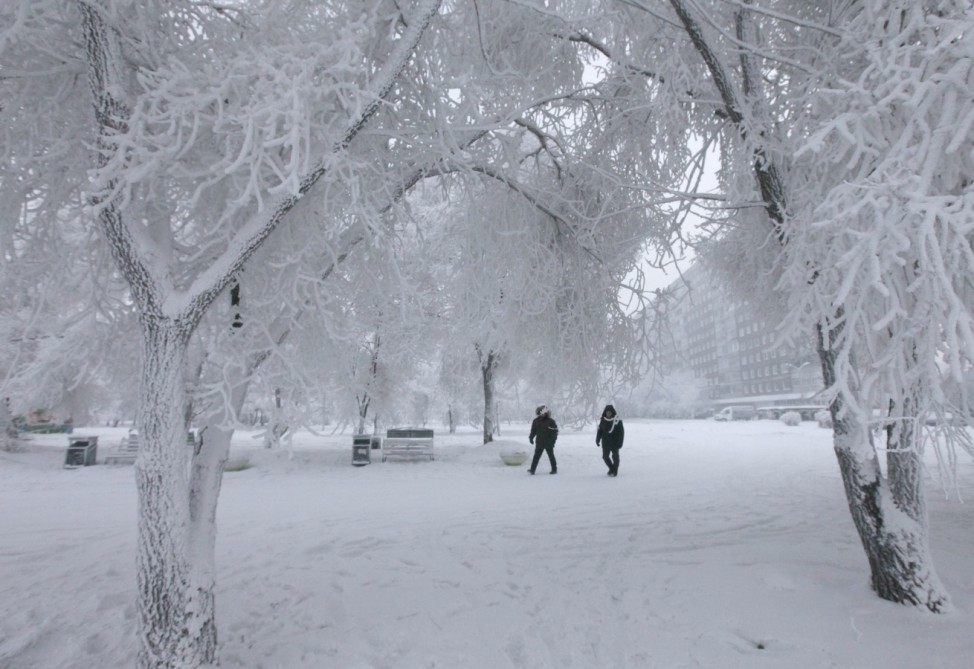 Two men walk along an embankment in an air temperature of about minus 30 degrees Celcius in Krasnoyarsk