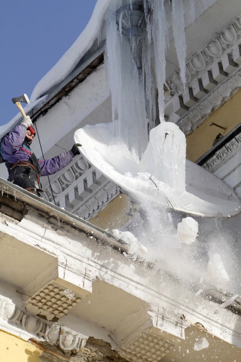 A worker breaks icicles from a roof in Kiev