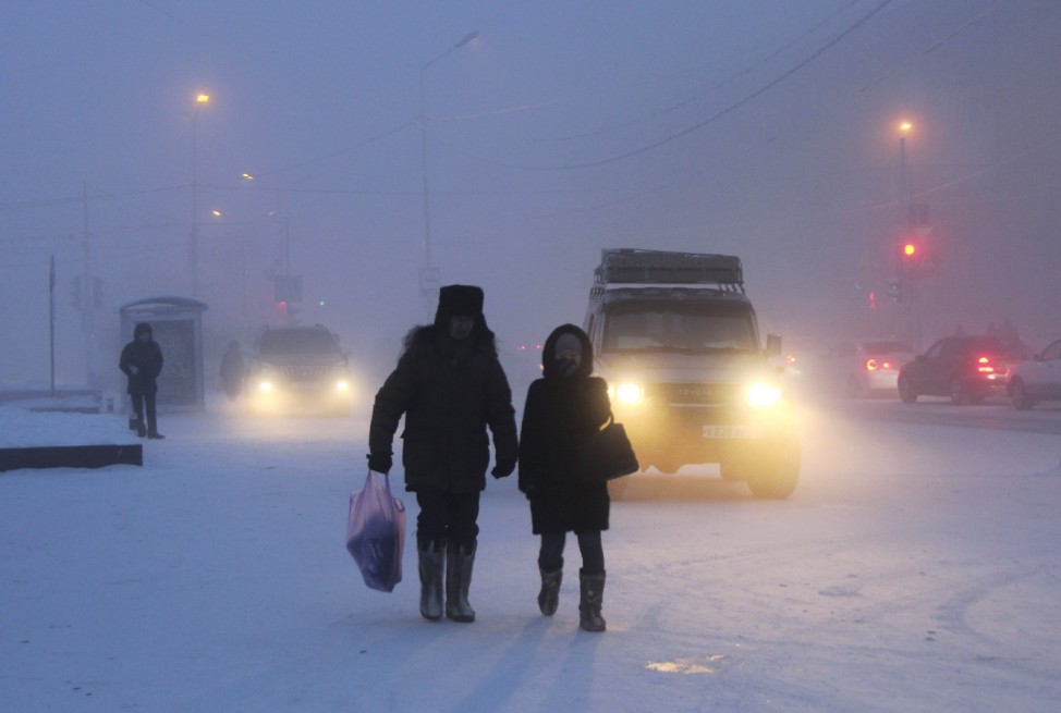 People walk along a street through frost mist in Yakutsk