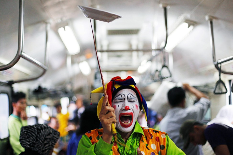 Indonesian clown Andri Hendri performs on a commuter train in Jakarta
