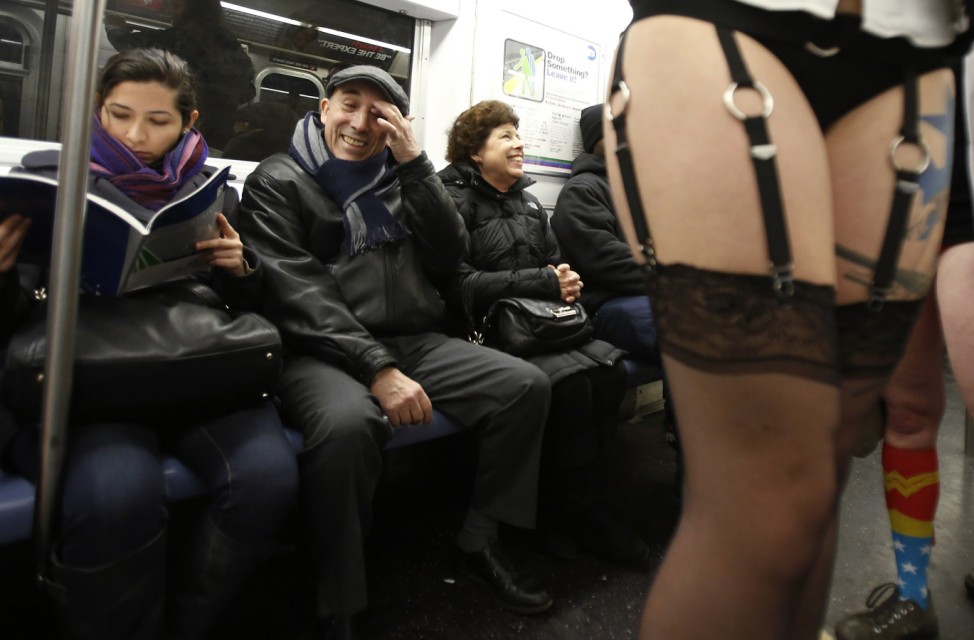 People watch as participants in the No Pants Subway Ride take the 6 train downtown in New York