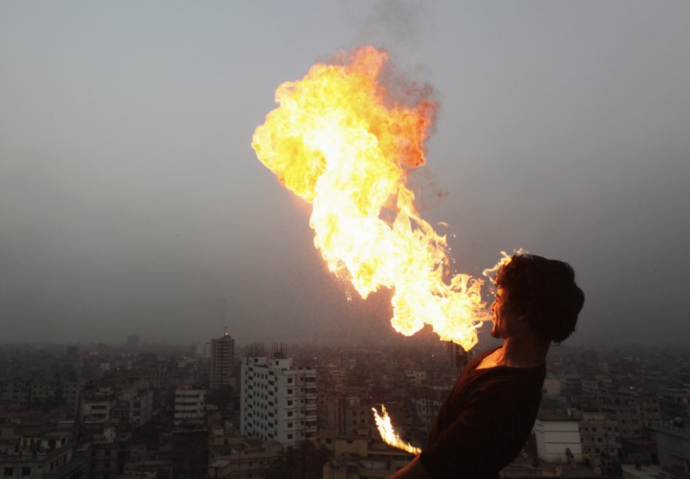 A man breathes out fire as he celebrates Poush Sankranti festival in Old Dhaka