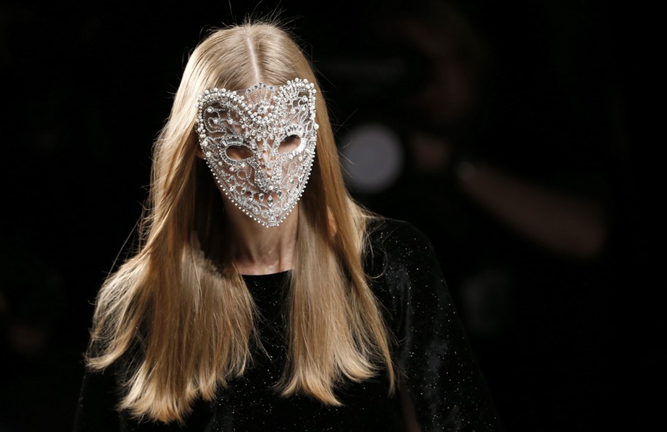 A modelwears a mask as she presents a creation by C'Est Tout at the Berlin Fashion Week Autumn/Winter 2013 in Berlin