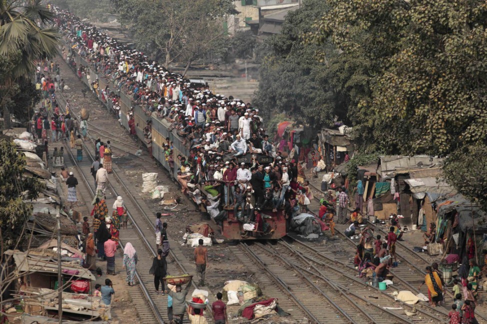 Commuters ride on the roof of a train as they come back to the city after attending the final prayer of Biswa Ijtema in Dhaka