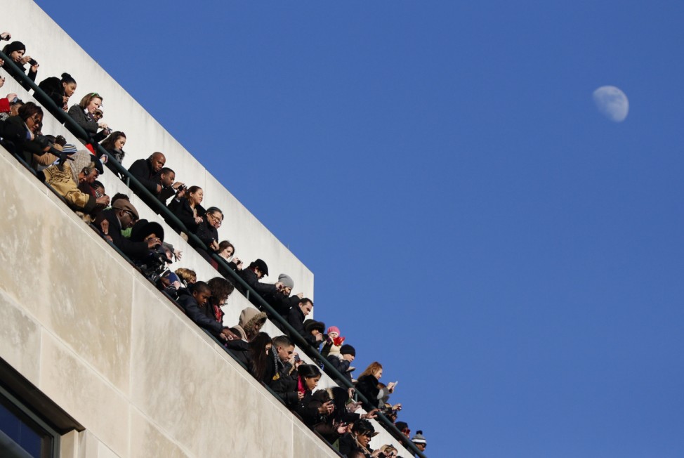 Spectators watch U.S. President Barack Obama go by during the inaugural parade in Washington
